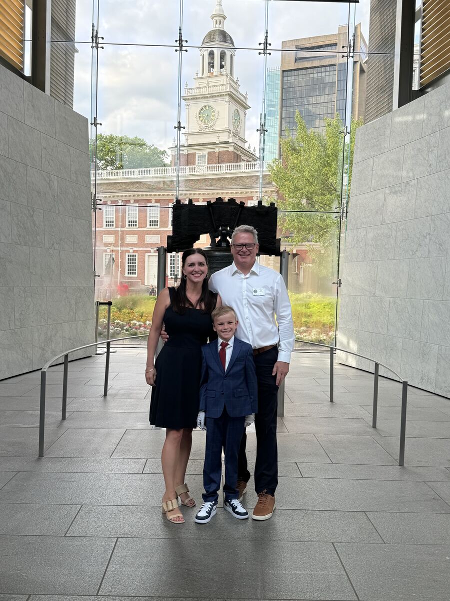 John Belman with his wife and son at the Liberty Bell, Independence Hall behind them.
